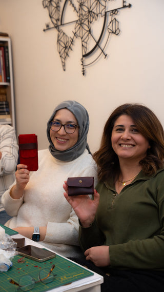 Deri workshop'ta birlikte yaptıkları ürünleri gösteren iki kişi — çiftler için birlikte üretme aktivitesi